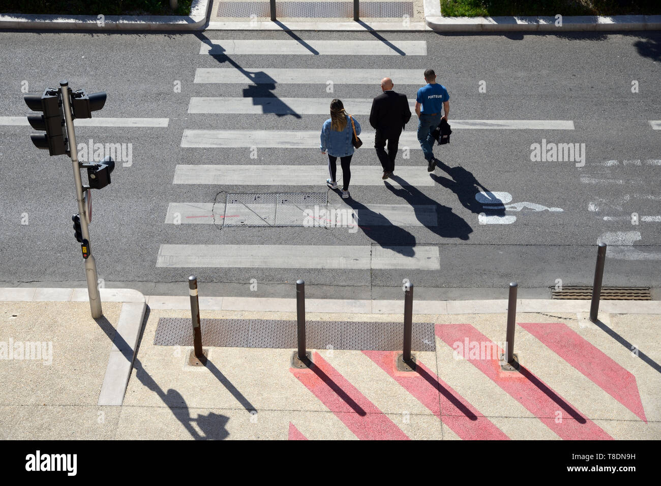 Angolo di alta vista di tre persone o pedoni che attraversano attraversamento pedonale o Zebra Marsiglia Francia Foto Stock