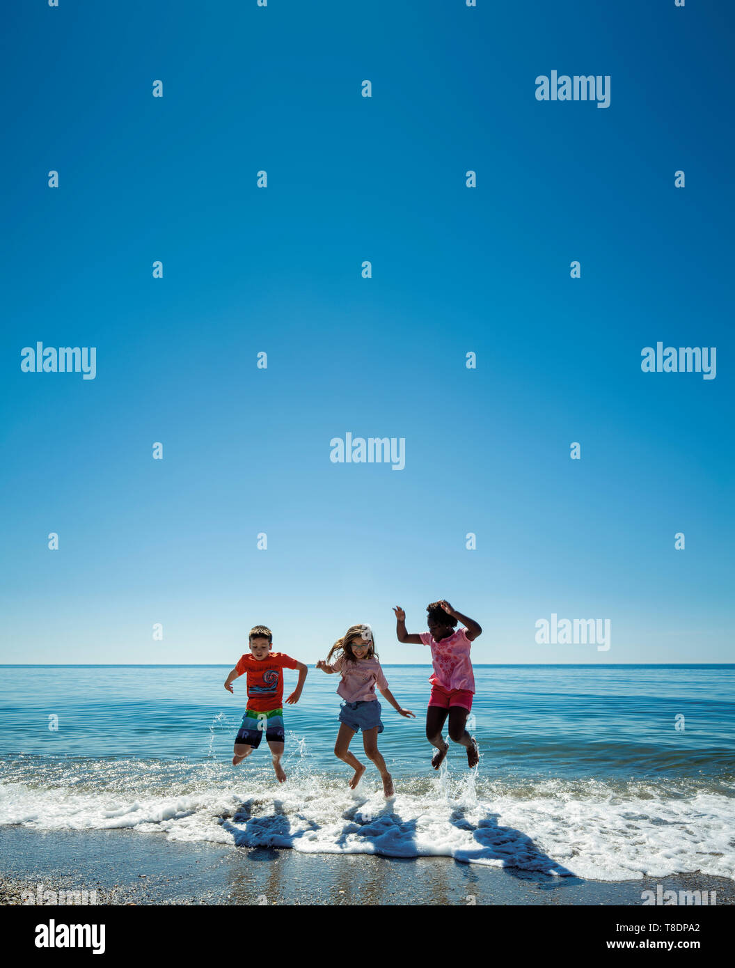 Un gruppo di bambini che si divertono sulla spiaggia. Mare Mediterraneo e cielo blu. Costa del Sol, Marbella. Andalusia, Spagna meridionale. Europa Foto Stock
