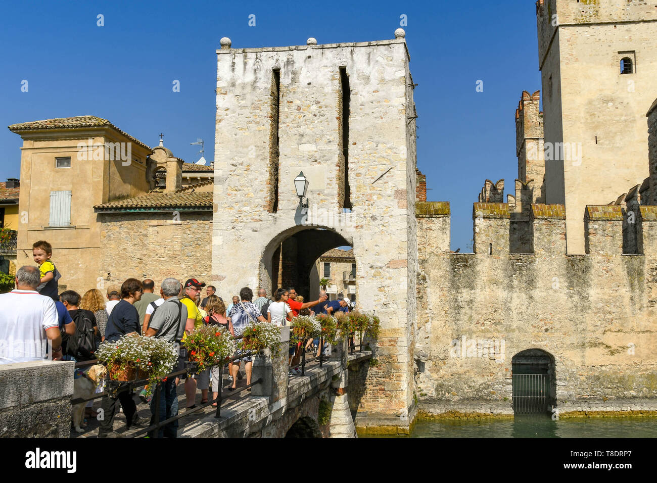 SIRMIONE SUL LAGO DI GARDA, Italia - Settembre 2018: persone attraversando un ponte per immettere la città vecchia e il Castello Scaligero. Si tratta di una fortezza medievale del lak Foto Stock