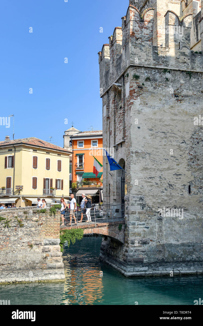 SIRMIONE SUL LAGO DI GARDA, Italia - Settembre 2018: persone attraversando il ponte sopra il fossato come provengono al di fuori del castello scaligero nel centro di Sirmione o Foto Stock