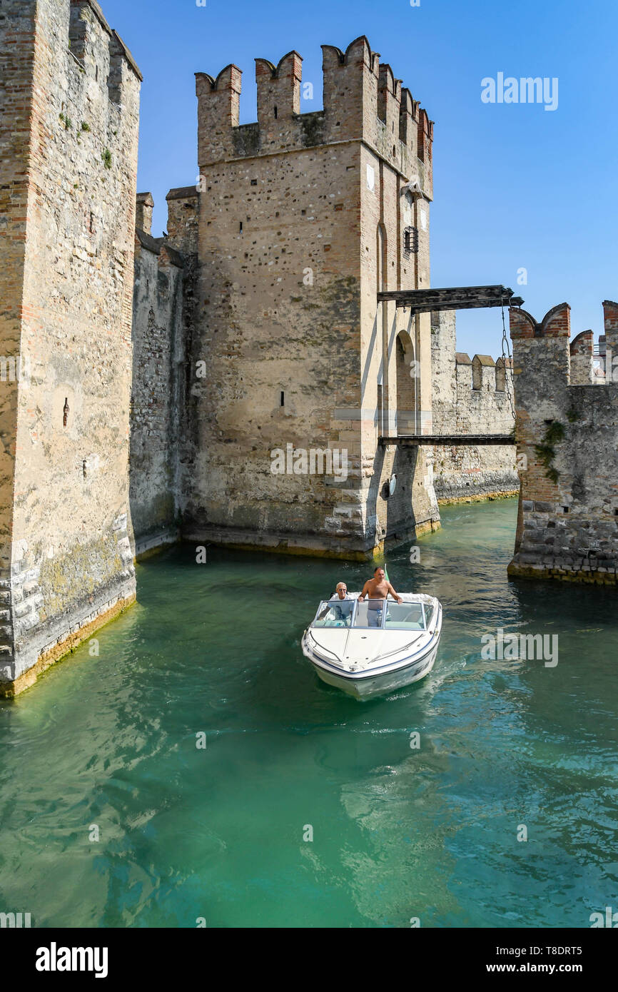 SIRMIONE SUL LAGO DI GARDA, Italia - Settembre 2018: la gente in un motore barca passato il Castello Scaligero nel centro di Sirmione sul Lago di Garda. Foto Stock