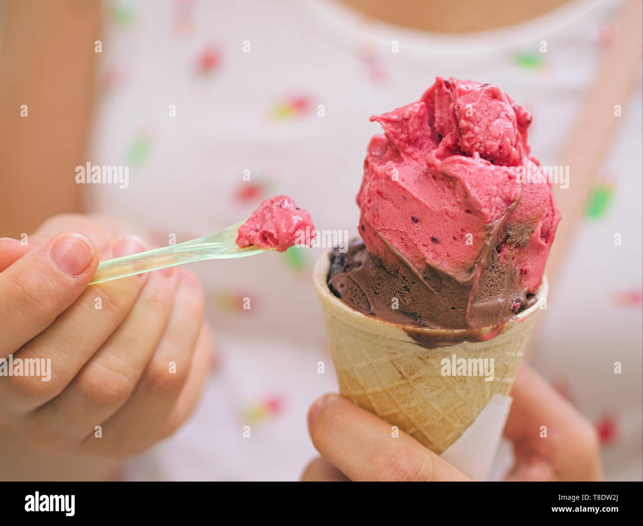 La donna a mangiare il gelato con plastica closeup cucchiaio Foto Stock