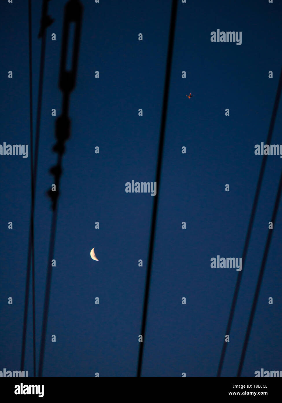 Una ceratura luna sopra la Penisola del Capo in Sudafrica mentre un aereo commerciale vola su una traccia alternativa attraverso il tettuccio di linee ferroviarie Foto Stock