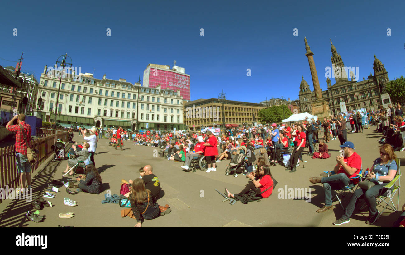 Glasgow, Scotland, Regno Unito, 12 maggio 2019, UK Meteo. Sunny scorcher di un giorno nel centro della città come George Square ospita un concerto per la encefalomielite myalgic (ME) come le persone godono di sun. Credito traghetto Gerard/Alamy Live News Foto Stock