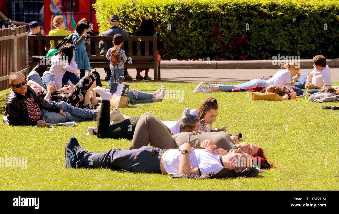 Glasgow, Scotland, Regno Unito, 12 maggio 2019, UK Meteo. Sunny scorcher di un giorno nel centro della città come George Square come persone godere il sole. Credito traghetto Gerard/Alamy Live News Foto Stock