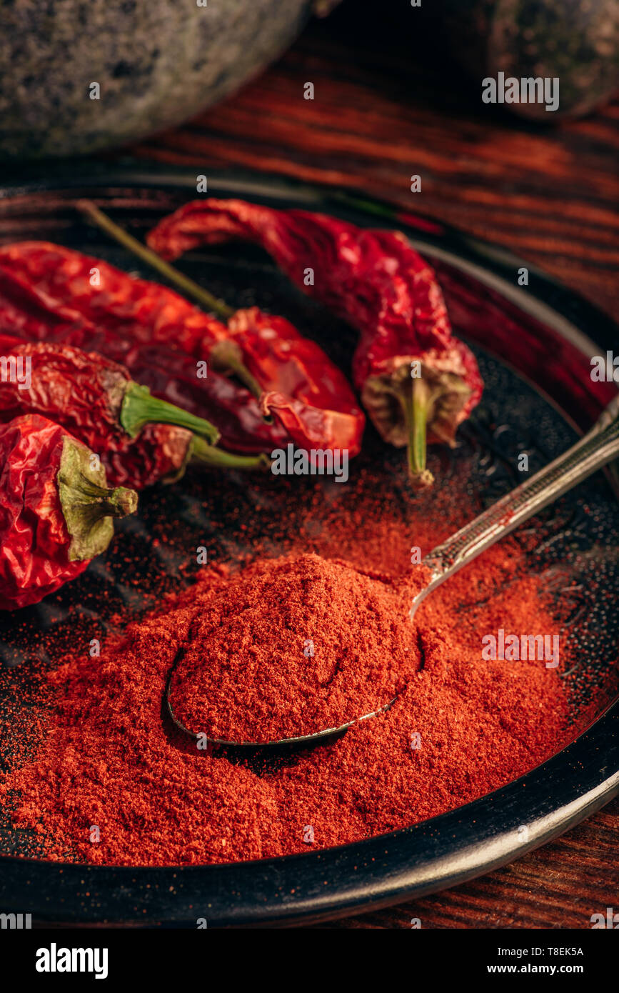 Cucchiaio di terra peperoncino con frutta secca sulla piastra di metallo Foto Stock