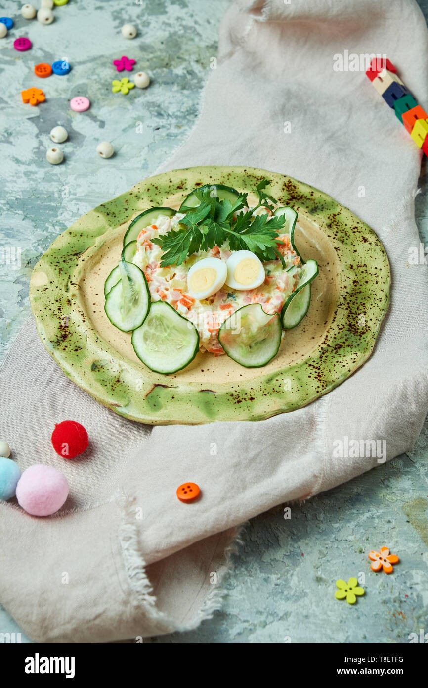 Per i bambini con insalata di granchio e fette di cetriolo su un bel piatto e uno sfondo grigio Foto Stock