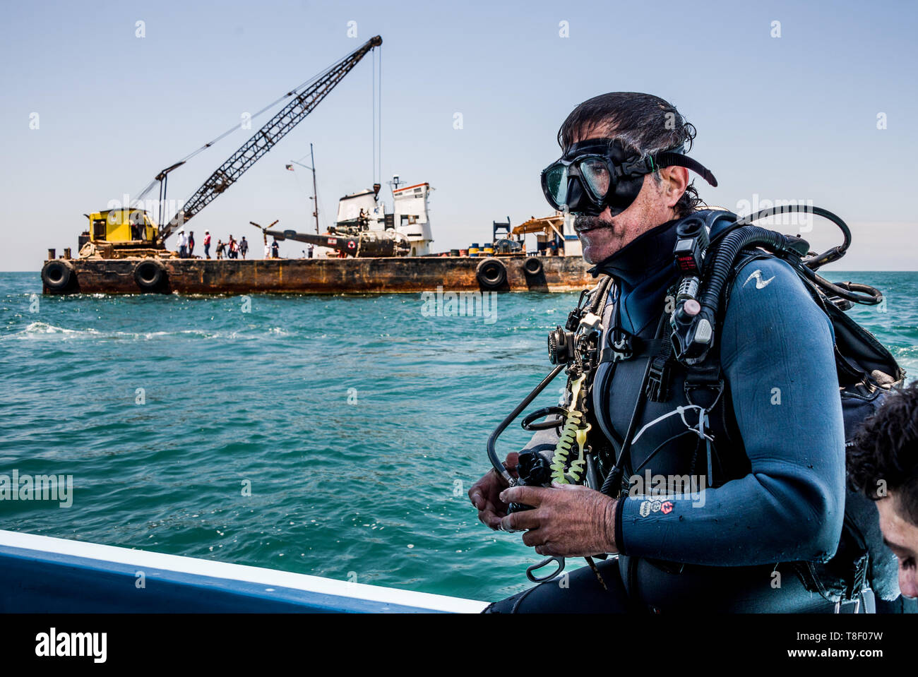 Mohamed Elserji, che è leader del progetto, visto la preparazione per entrare in acqua con il compito di supervisionare l'abbassamento del velivolo all'oceano pavimento e accertandosi che siano correttamente fissati durante il progetto. Dismessi velivoli sono winched nell'acqua fuori la città di Saida in Libano come parte di un progetto di conservazione per creare un reef artificiale. Il fondo del mare qui è arido così l idea è quella di fornire i pesci e invertebrati con strutture permanenti per dare loro un posto di razza e rifugio al fine di aumentare i pesci e vita marina stock per la pesca e il turismo. Foto Stock