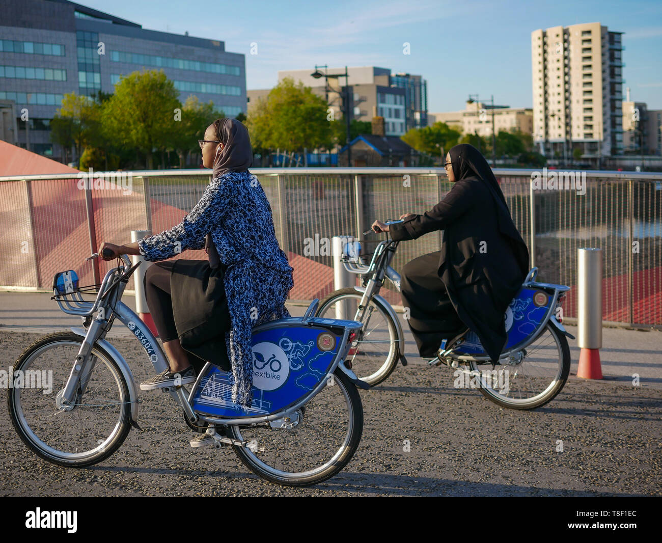 Pubblico di Cardiff Noleggio biciclette essendo utilizzato da giovani sulla strada a Cardiff Bay Foto Stock