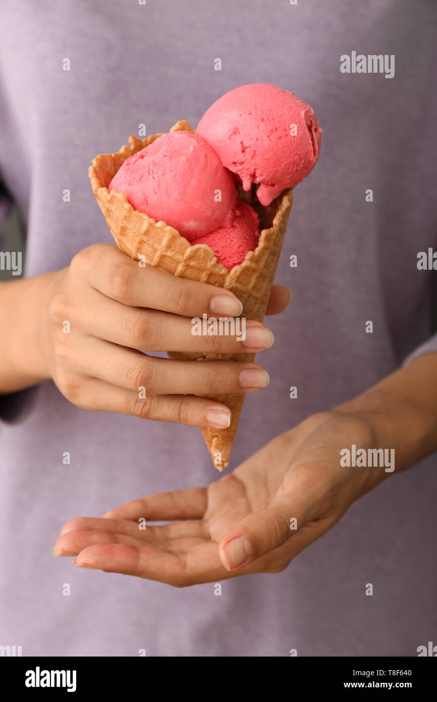 Donna tenendo cono di cialda con fragola deliziosa di gelati, primo piano Foto Stock
