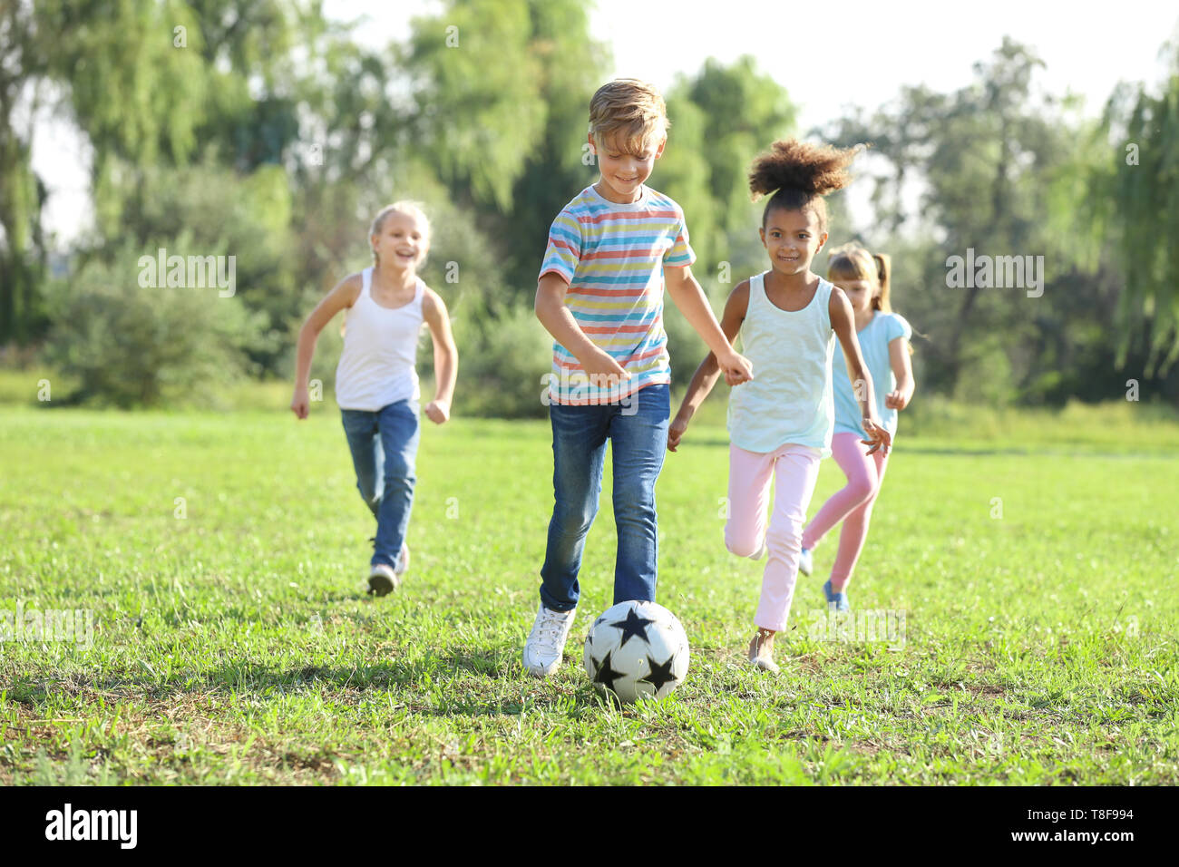 Carino piccolo i bambini a giocare a calcio all'aperto Foto Stock