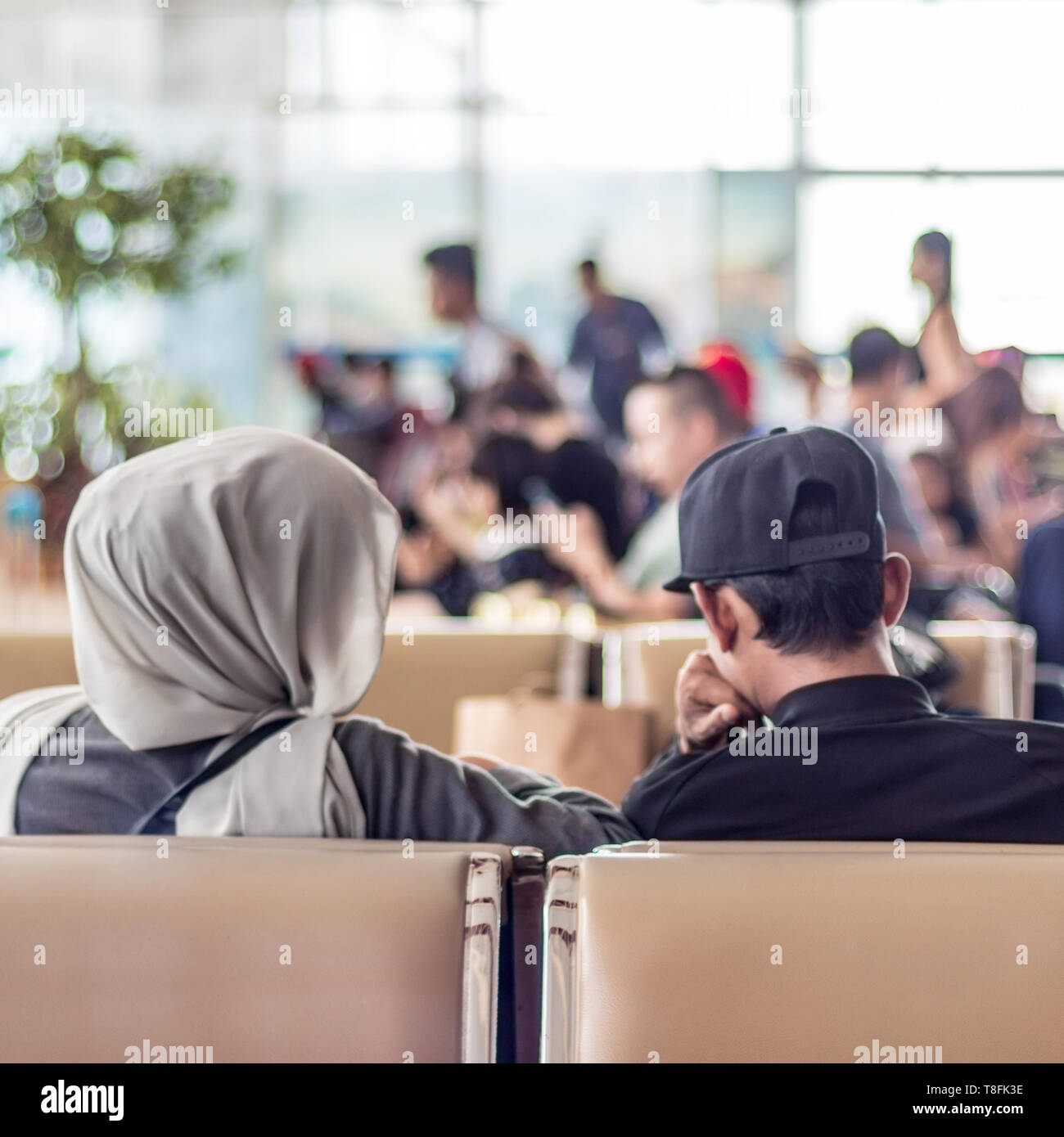 Moderno islamico musulmani asian giovane seduto e in attesa di un volo in partenza a international airport terminal Foto Stock