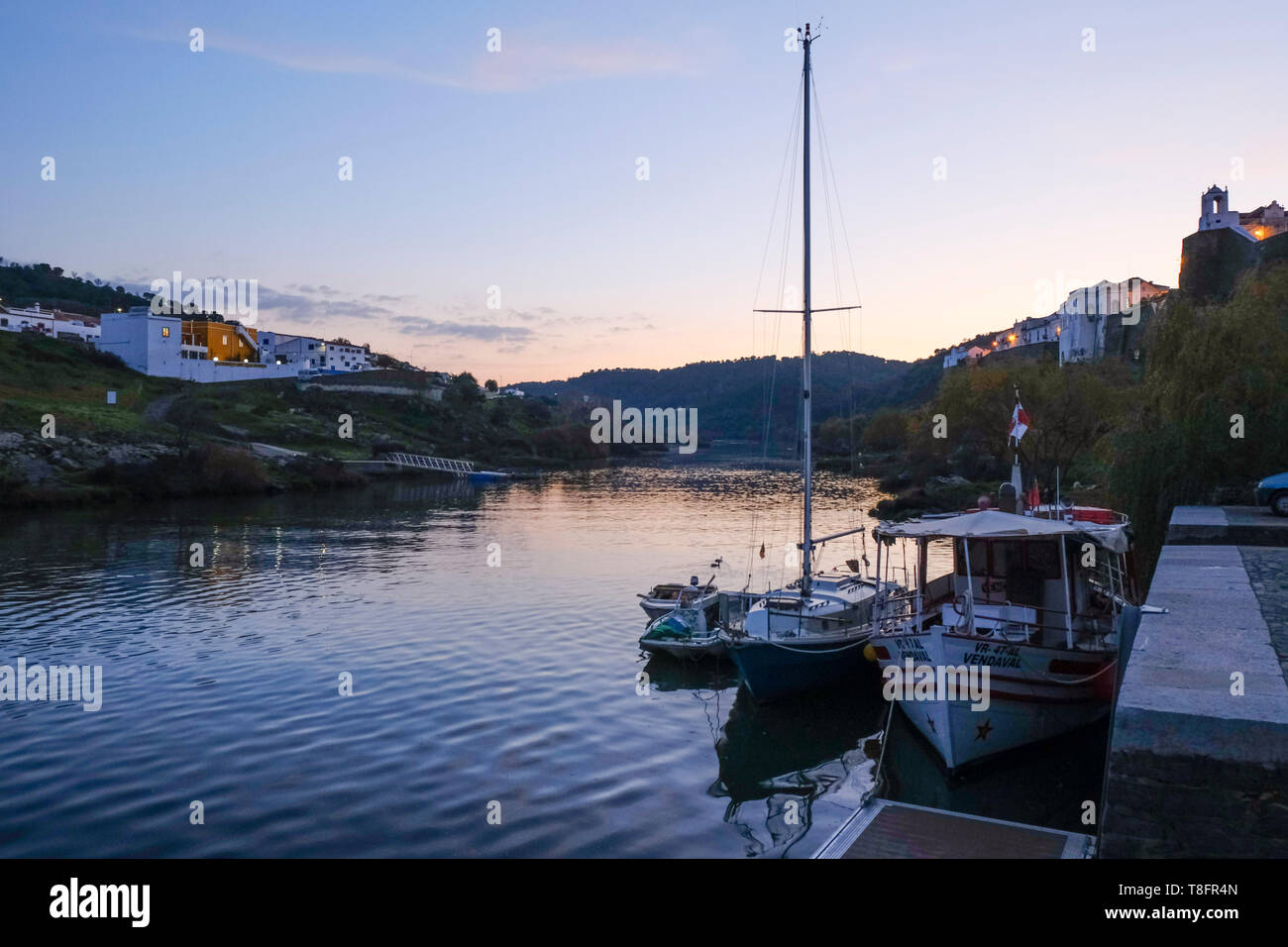 Riverside, della città murata di Mértola, nel sud-est della regione Alentejo, Portogallo. Il fiume è chiamato Guadiana. Parque Natural do Vale do Guadiana. Foto Stock