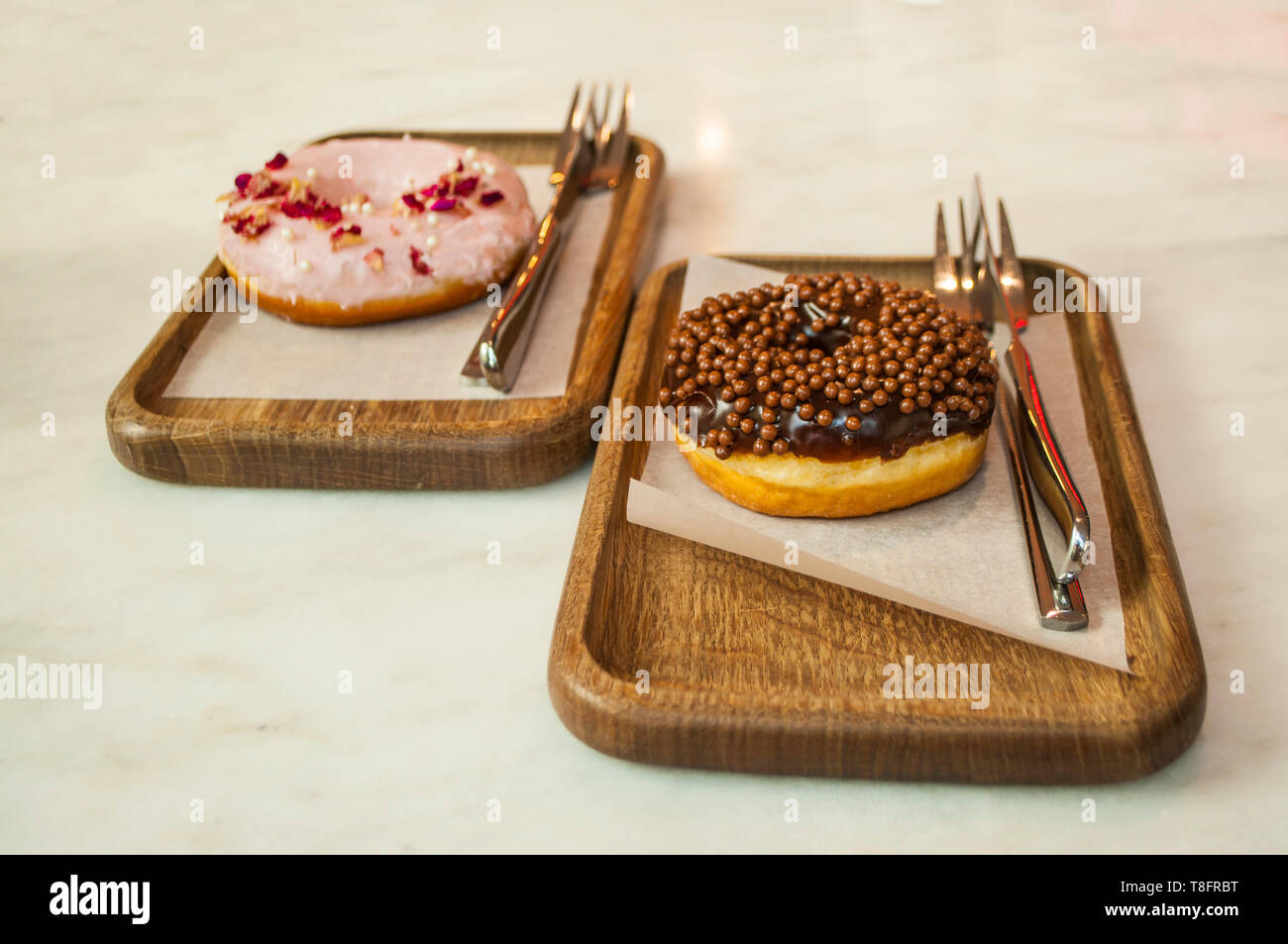 Delicicous ciambelle dolci su piastre di legno su un tavolo in un bar. Foto Stock
