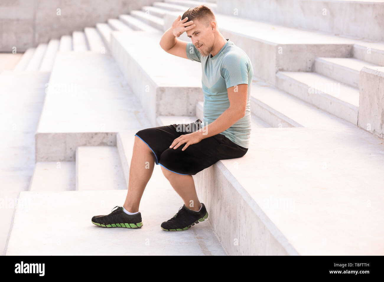 Sporty giovane di riposo dopo la formazione all'aperto Foto Stock