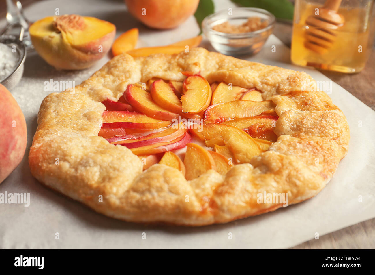 Pergamena con deliziosa peach galette su tavola Foto Stock