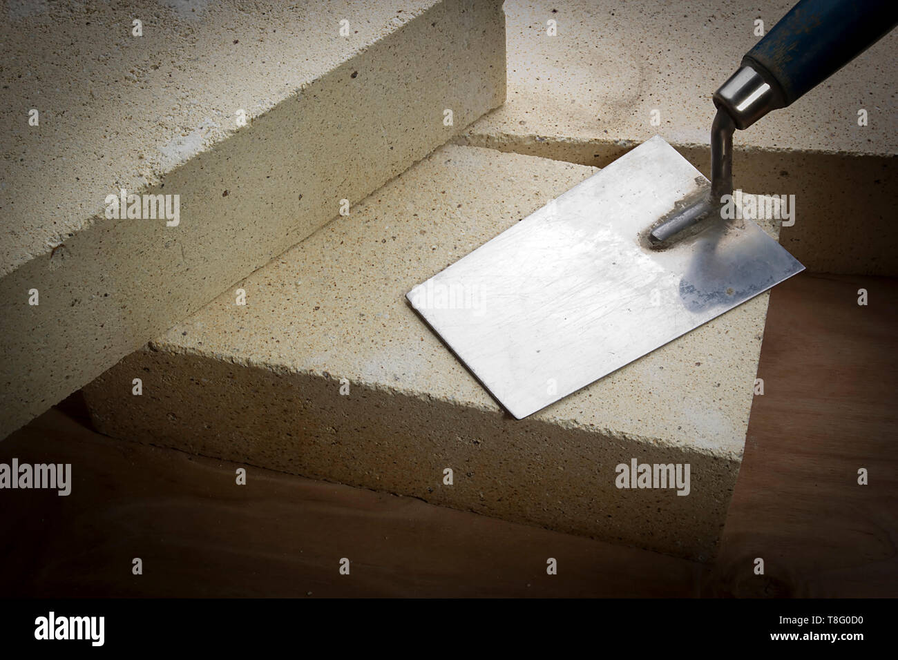 Fire mattoni e frattazzo su una superficie in legno Foto Stock