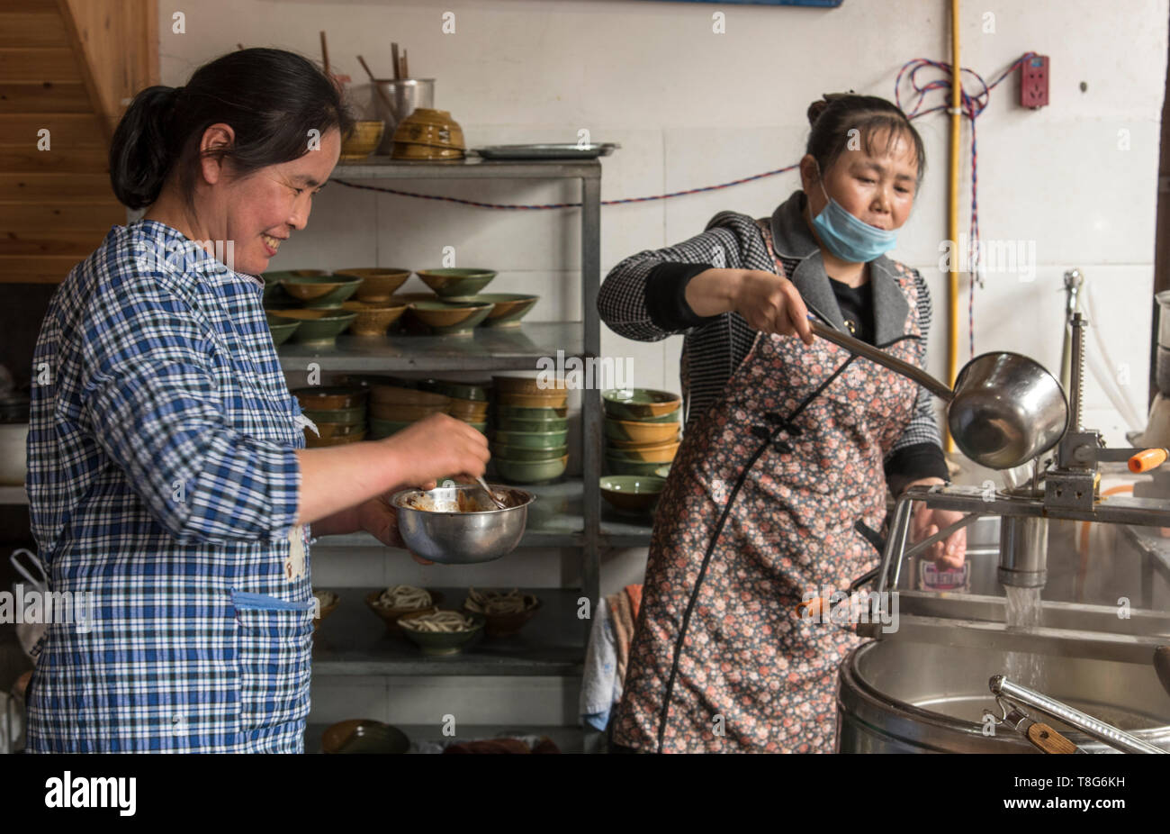 Cinese il cibo di strada. Cibo distributore vende prodotti alimentari in una fase di stallo nel Sichuan, in Cina Foto Stock