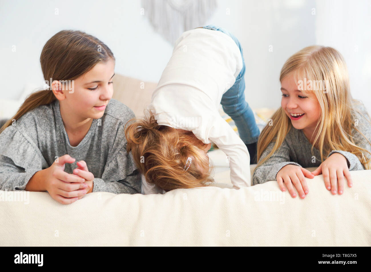 Tre felice piccole sorelle su un letto avente fun Foto Stock