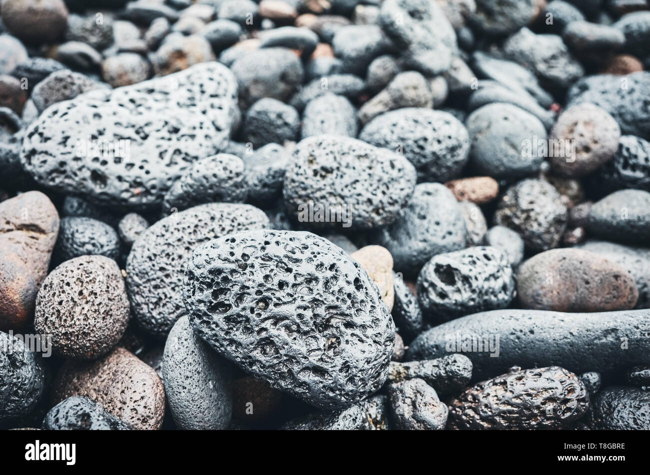 Sfondo naturale costituita da rocce di origine vulcanica e ciottoli, il fuoco selettivo, tonificazione del colore applicato. Foto Stock