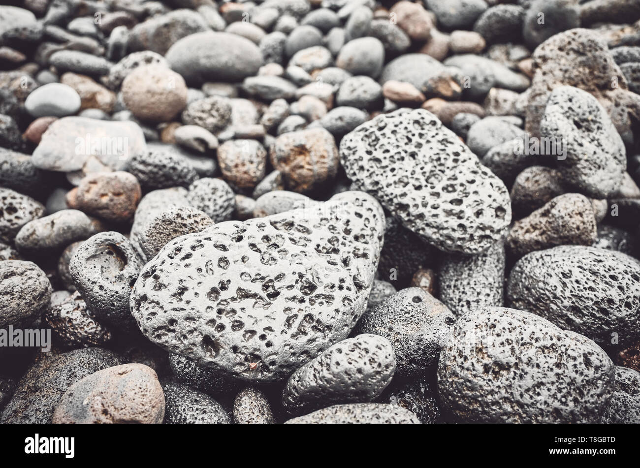 Sfondo naturale costituita da rocce di origine vulcanica e ciottoli, il fuoco selettivo, tonificazione del colore applicato. Foto Stock