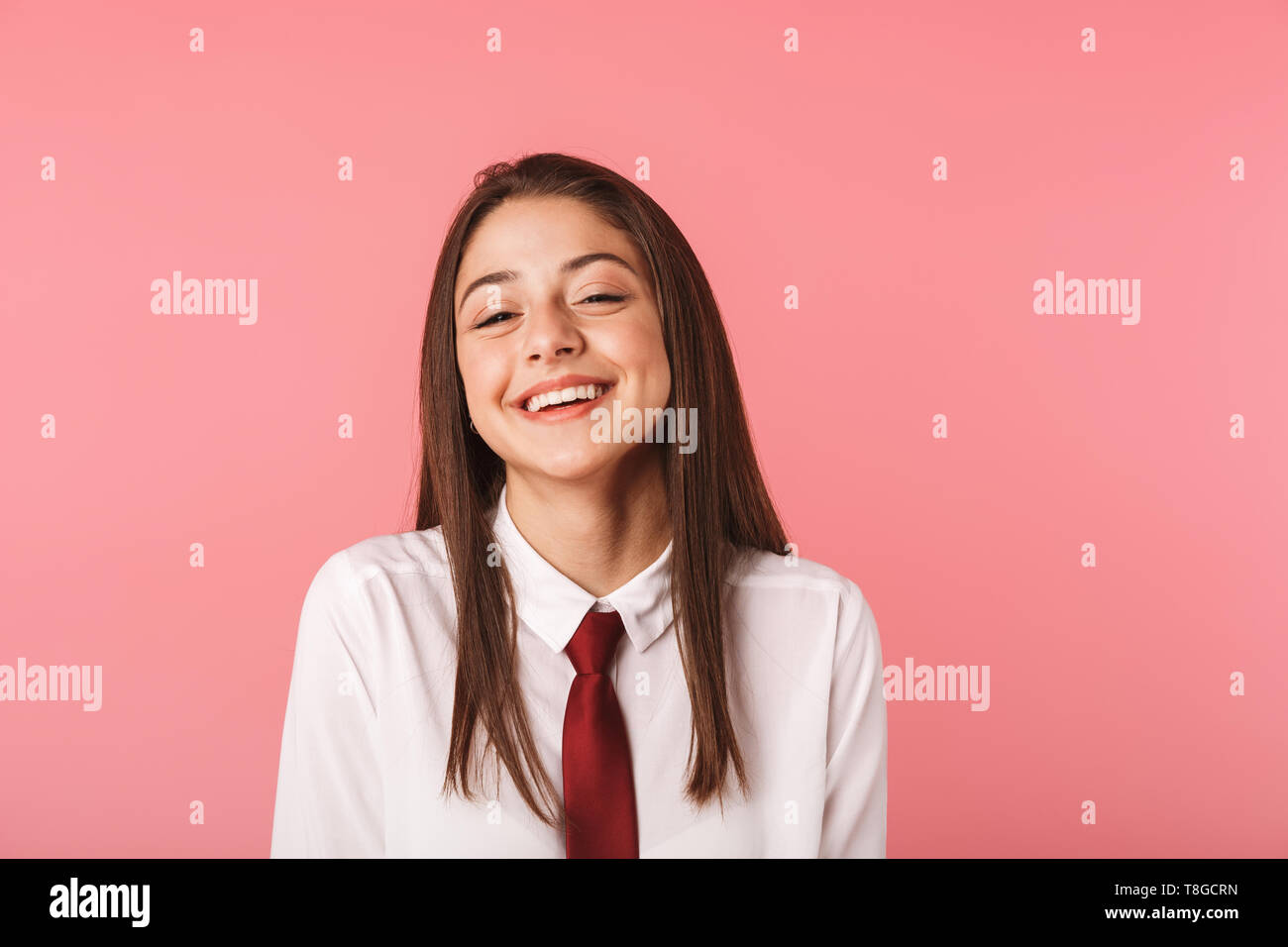 Ritratto di ragazza caucasica 15-16y in uniforme scolastica in piedi isolato su sfondo rosso Foto Stock