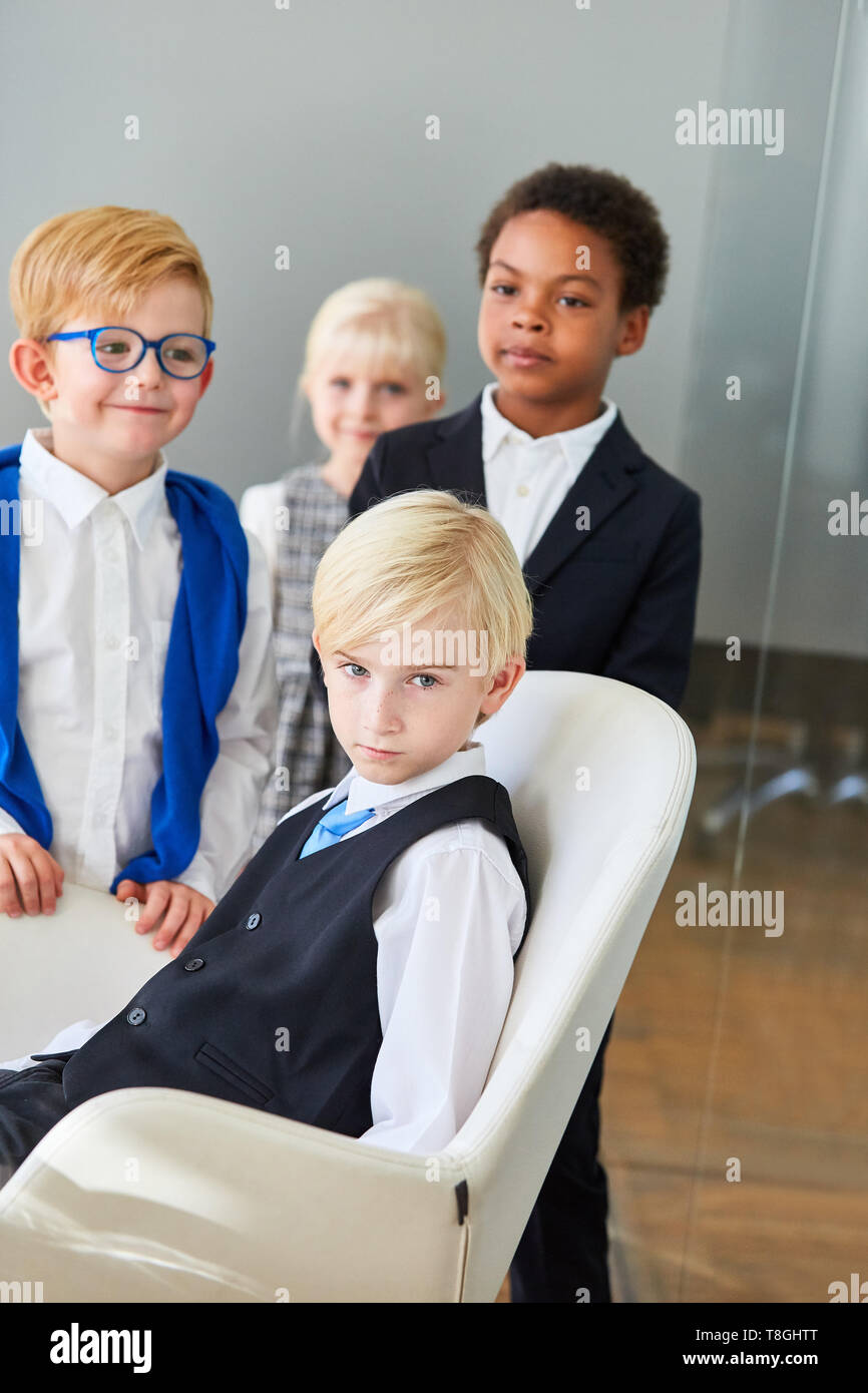 Gruppo di bambini mascherati come la gente di affari in multiculturale del team aziendale Foto Stock