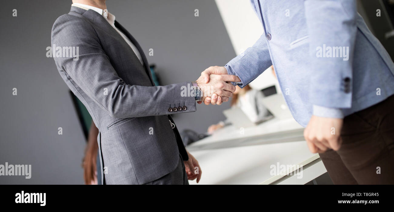 Due fiducioso uomo d affari si stringono la mano durante una riunione in ufficio Foto Stock