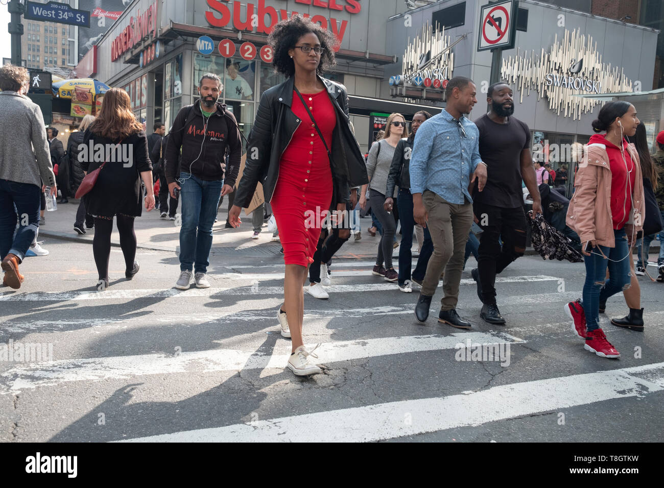 Un gruppo diversificato di pedoni sull'Ottava Avenue attraversando West 34th Street vicino a Penn Station a Manhattan. Foto Stock
