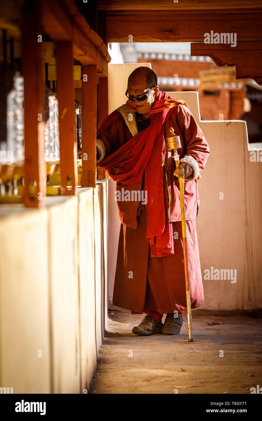 India, stato di Jammu e Kashmir, Himalaya, Ladakh, Indus Valle, monaco girando le ruote di preghiera nel cortile del gompa (monastero di Hemis Foto Stock