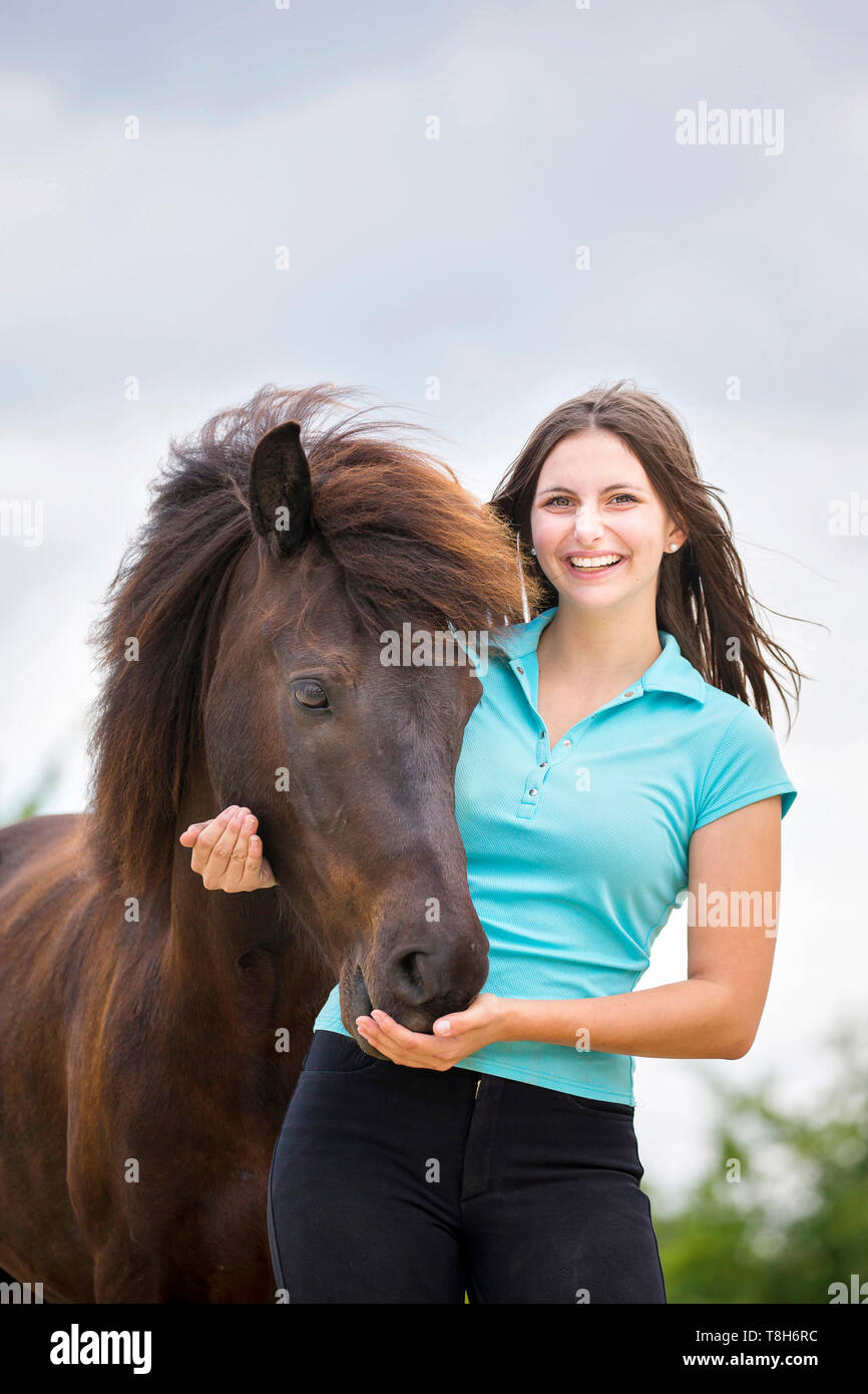 Cavallo islandese. Giovane donna smooching con nero castrazione. Austria Foto Stock