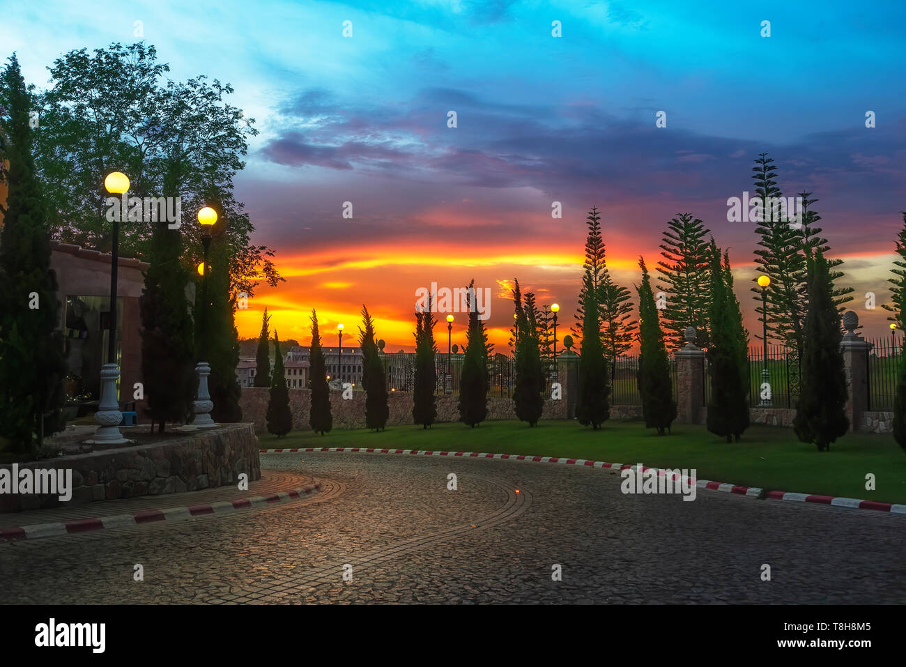 Tramonto colorato su una tranquilla strada curva Foto Stock