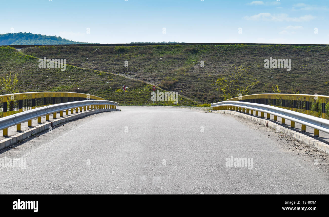 Immagine simmetrica lungo il ponte di vuoto sulla strada asfaltata. Foto Stock