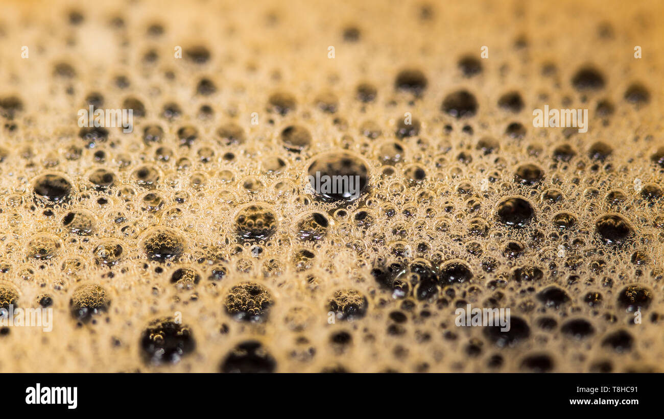 Caffè texture di superficie. Le bolle di schiuma in dettaglio. Aromatica bevanda calda. Abstract background schiumoso. Mirroring in bollicine del liquido marrone. Bevanda con caffein. Foto Stock
