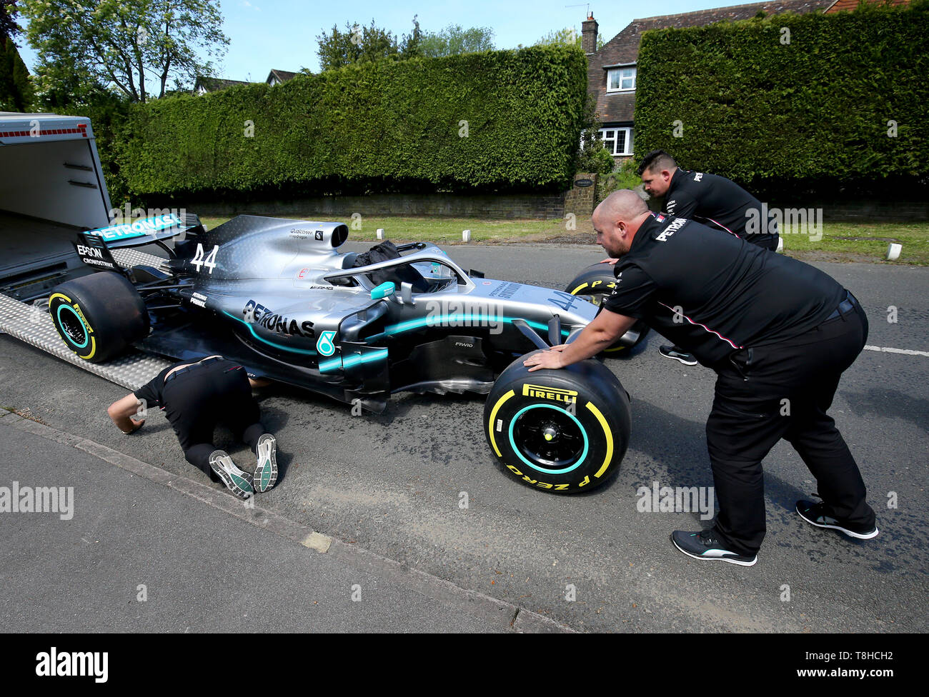 Membri della Mercedes Formula One team a fornire una replica di Lewis Hamilton della vettura di Formula 1 per la casa di cinque anni di Harry Shaw in Redhill Surrey, che è stato diagnosticato con una rara forma di cancro osseo. Foto Stock