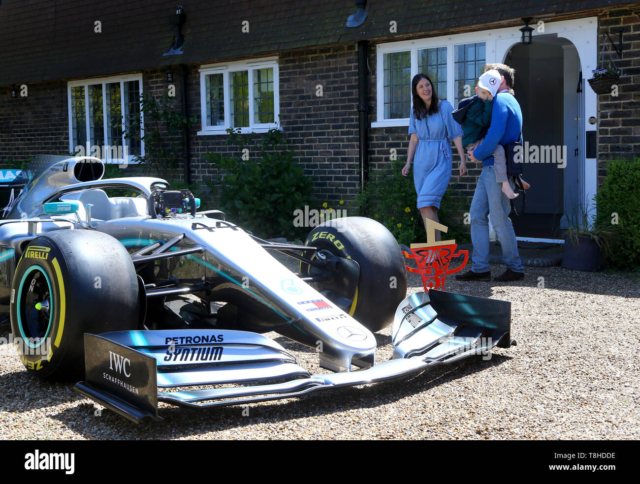 Cinque anni di Harry Shaw, che è stato diagnosticato con una rara forma di cancro osseo, è portato da suo padre James con la madre Charlotte per visualizzare una replica di Lewis Hamilton della vettura di Formula 1 al di fuori della loro casa in Redhill, Surrey. Foto Stock