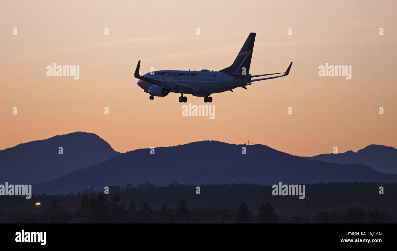 Richmond, British Columbia, Canada. Il 9 maggio, 2019. Un WestJet Boeing 737-700 (C-FGWJ) a singola corsia jetliner terre al tramonto, dall'Aeroporto Internazionale di Vancouver. Credito: Bayne Stanley/ZUMA filo/Alamy Live News Foto Stock