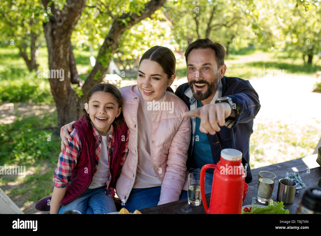 La famiglia felice gustarsi uno spuntino in park pavillion Foto Stock