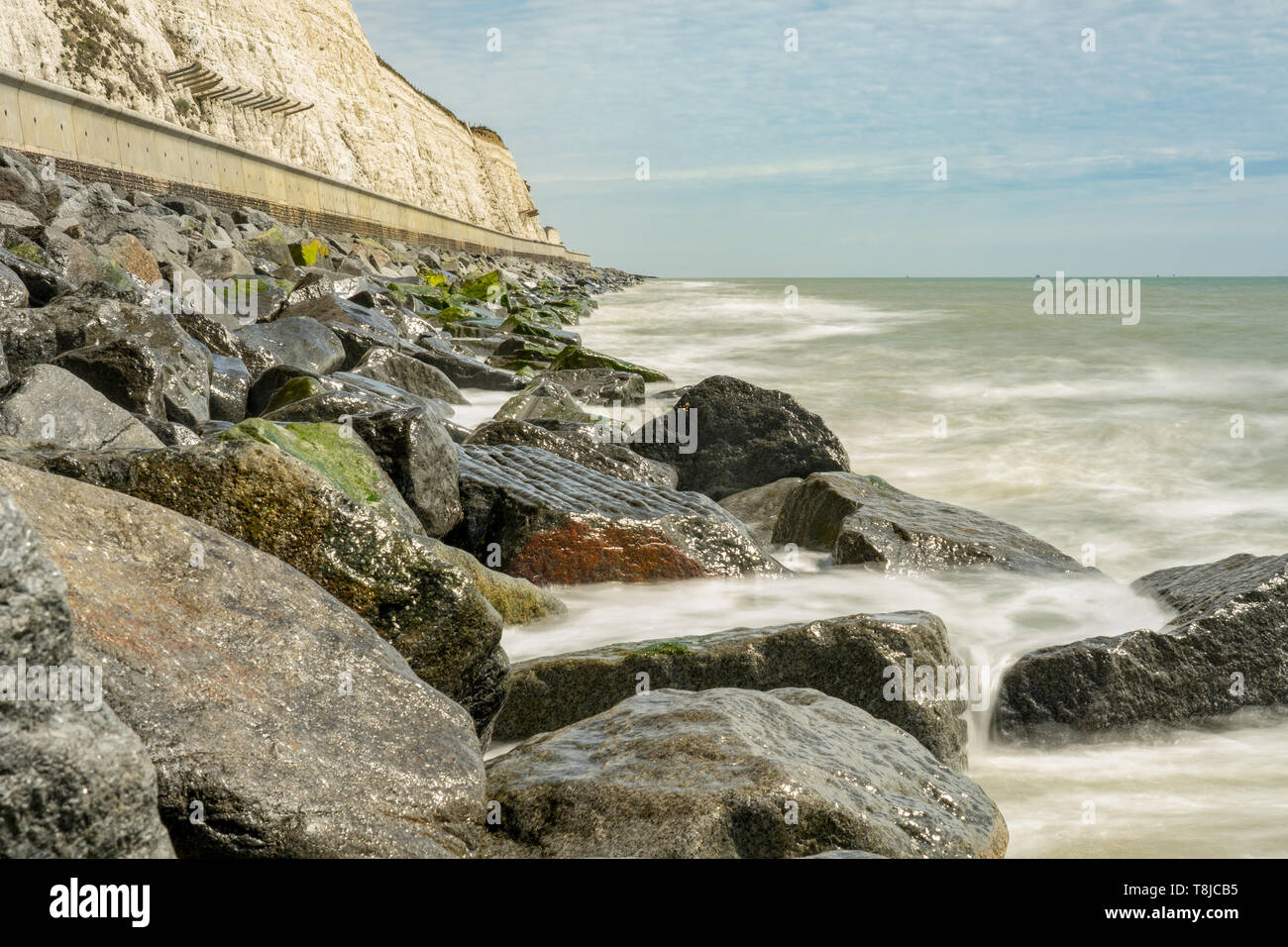 Gentle Waves colpendo rocce costiere Foto Stock