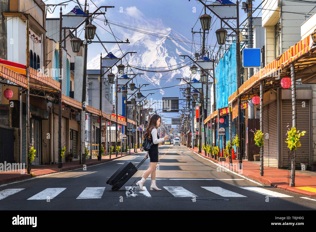 Donna che cammina sulla strada in Fujiyoshida con lo sfondo del monte Fuji, Giappone. Foto Stock