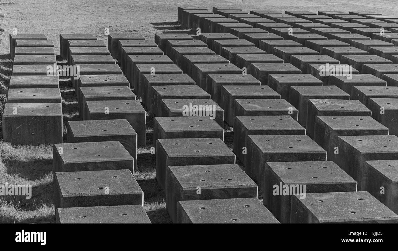 Un tipico paesaggio Olandese di IJmuiden in mare, i blocchi di calcestruzzo sono memorizzati sulla terra per essere in grado di riparare le pareti di protezione del porto di IJmuiden. Foto Stock