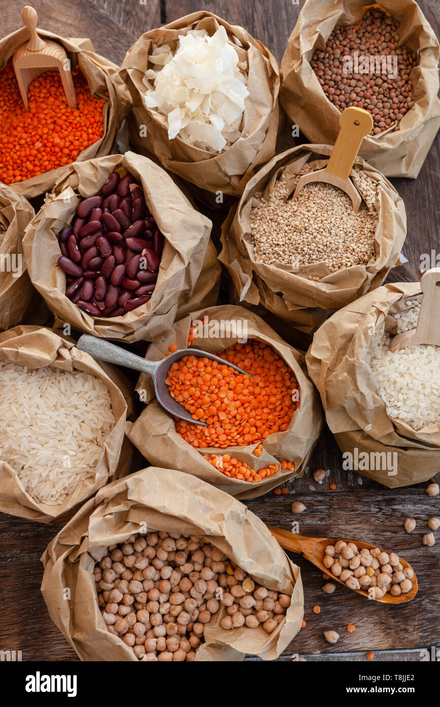 Varietà di legumi secchi e cereali in piccoli sacchetti di carta Foto Stock