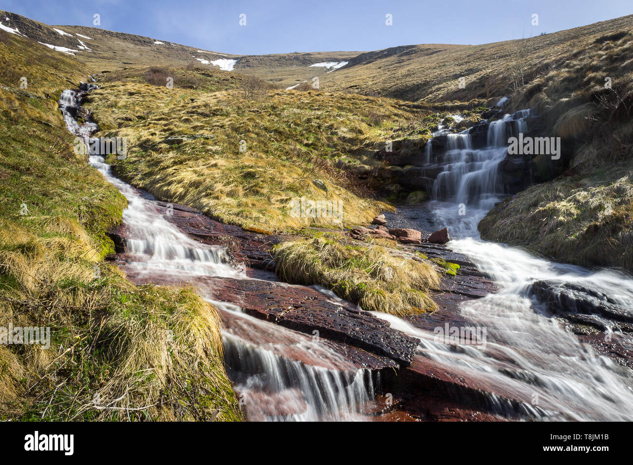 Due ruscelli di montagna a cascata verso il basso le rocce rosse e la fusione per formare Monaco salto della cascata, la più alta in Serbia, durante la primavera Foto Stock