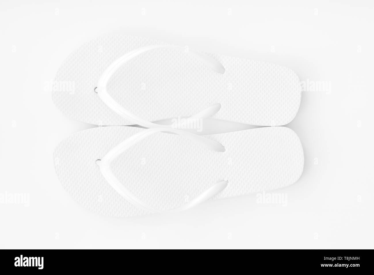 White flip flop su uno sfondo bianco. Luminoso e di alta esposizione della chiave. Foto Stock