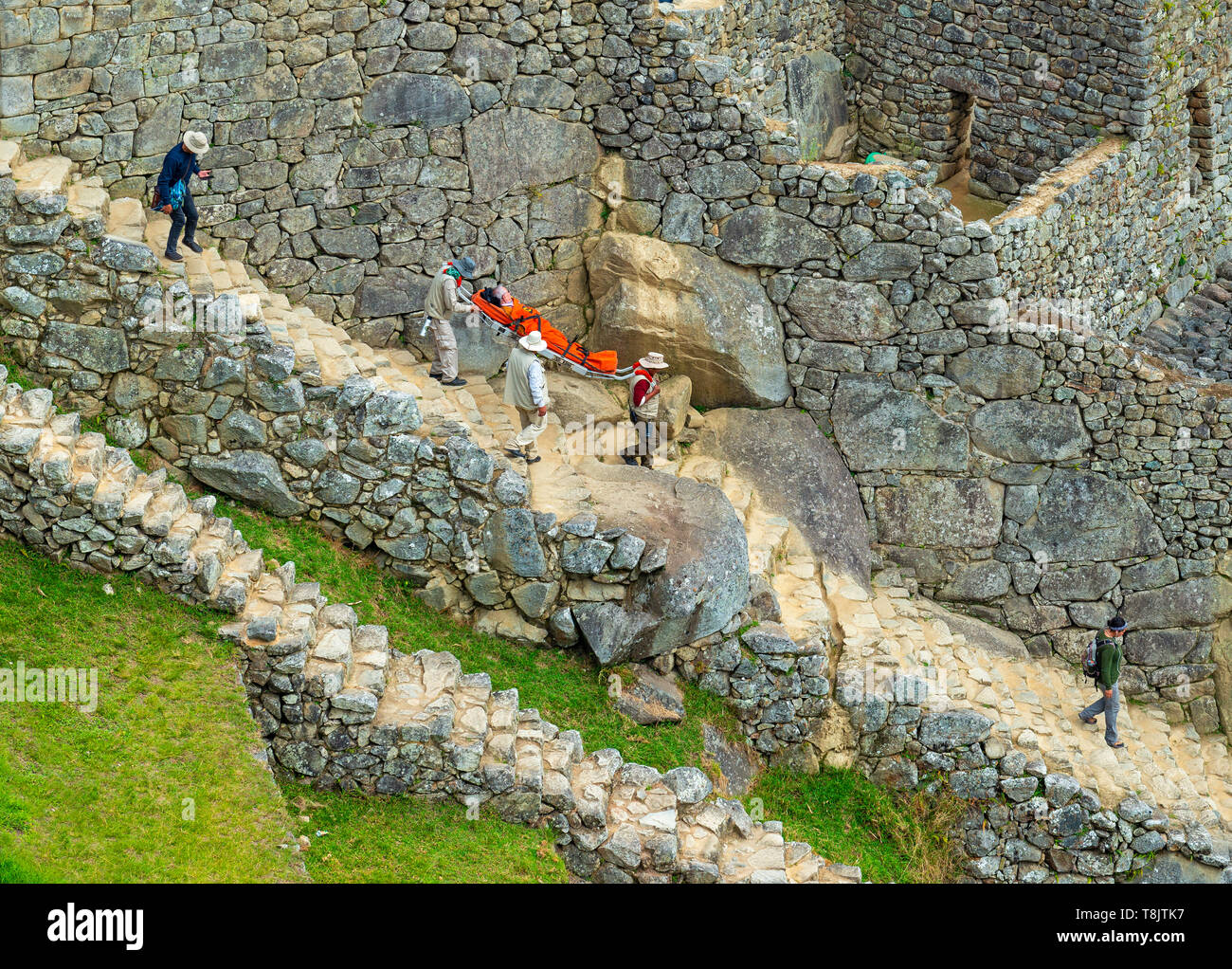 Emerengy nel sito Inca di Machu Picchu come un uomo anziano e turistico è portato via in una barella a causa di malessere da altitudine e disidratazione, Perù. Foto Stock