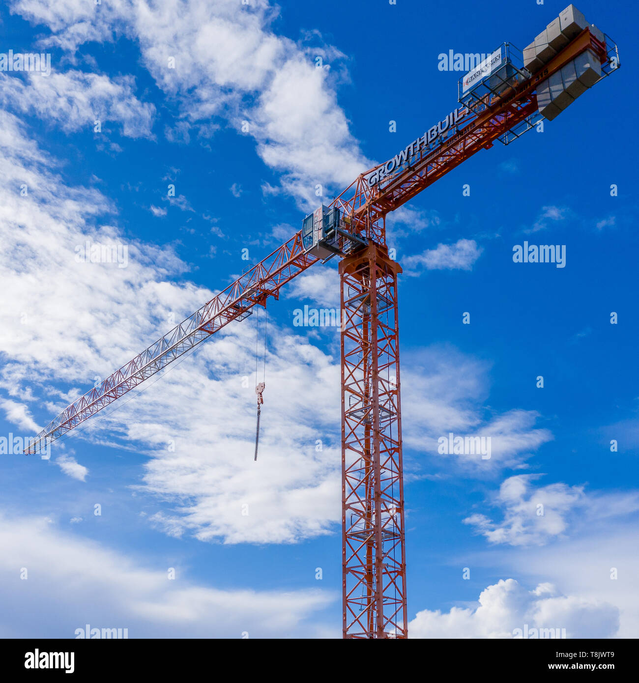 Pymble, Sydney, Australia - 5 Maggio 2019: Tall gru a torre su sito in costruzione con cielo blu e nuvole dietro. Gru da KraneWorx e costruzione b Foto Stock