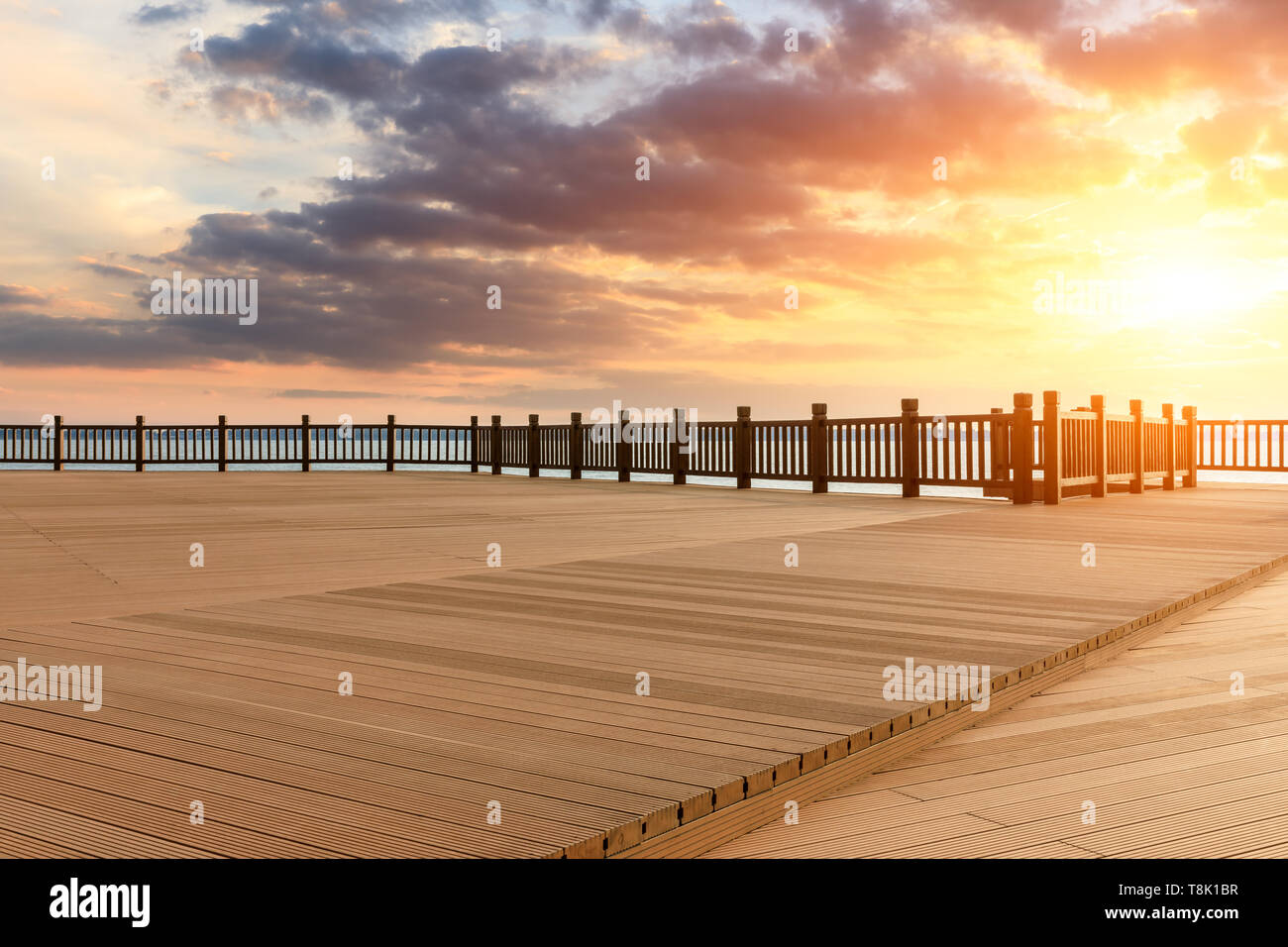 Lakeside pavimento in legno e la piattaforma sky nuvole al tramonto Foto Stock