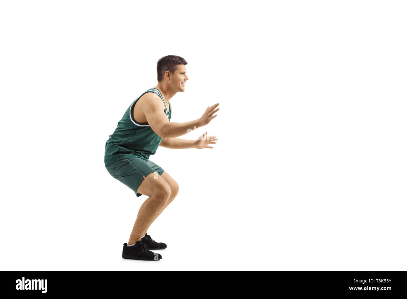 Lunghezza piena ripresa di profilo di un uomo che giocano difesa nel basket isolato su sfondo bianco Foto Stock