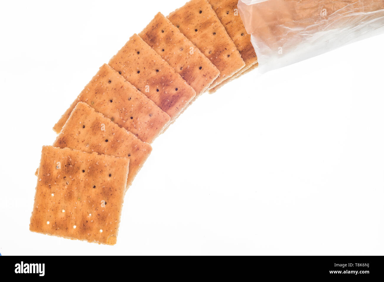 Inquadratura orizzontale di tutto il frumento crackers fuoriuscita dalla confezione. Isolato su bianco. Foto Stock