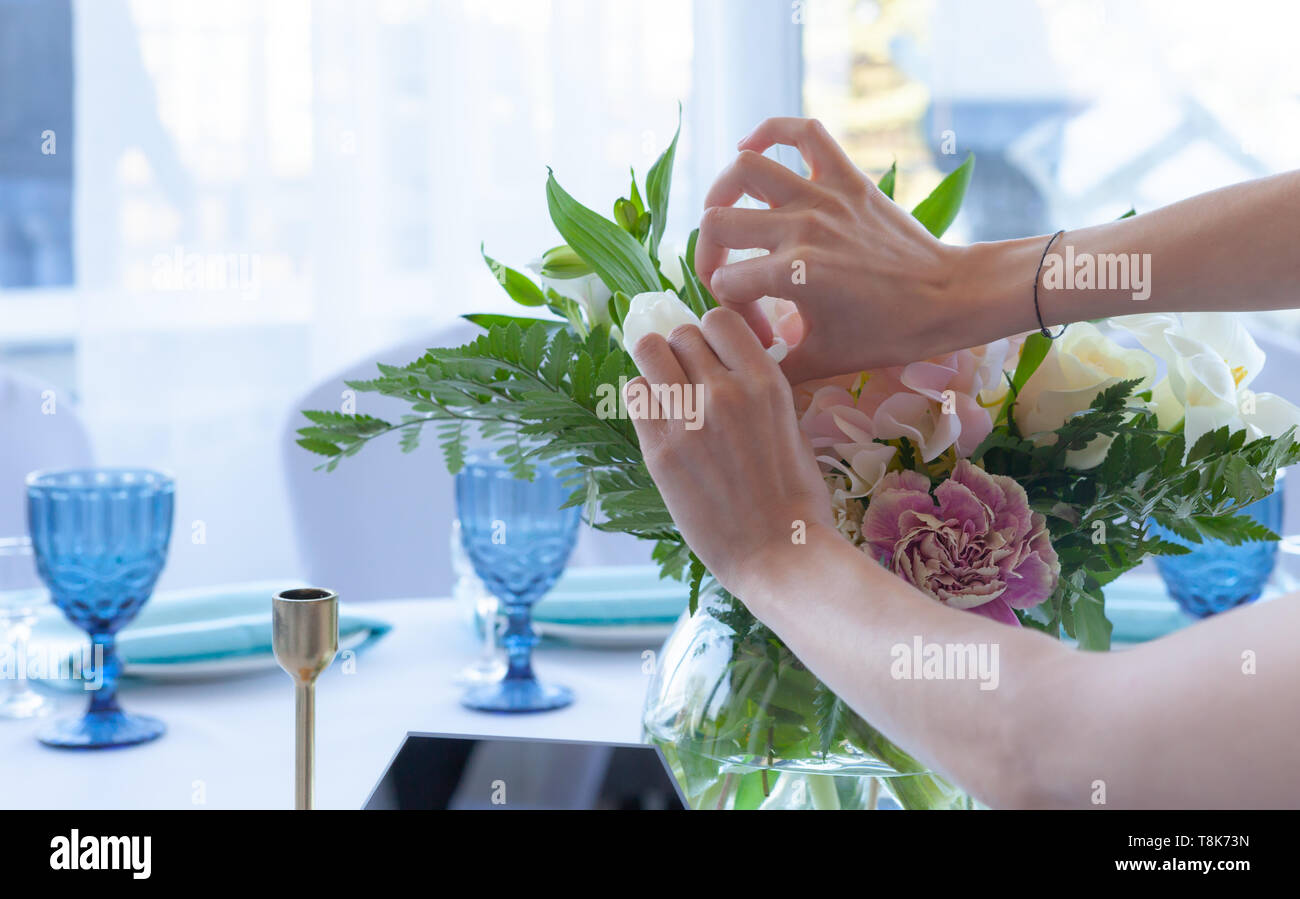 Ragazza di fiorista Prepara i fiori per una festa di nozze Foto Stock